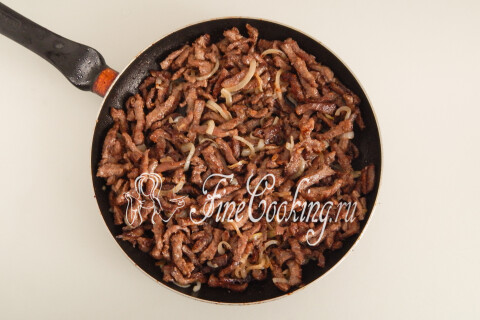 Обжаренная говядина с мясным соком, возвращённая в сковороду с луком.