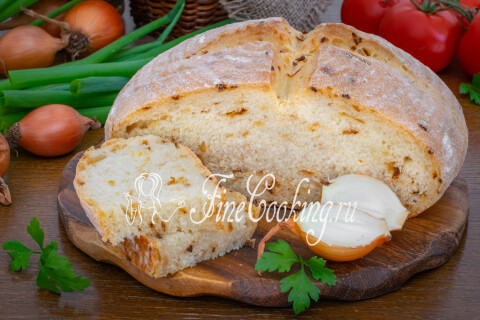 Луковый хлеб с румяной хрустящей корочкой на разделочной доске.