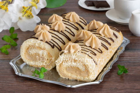 Бисквитный рулет с творожным кремом, нарезанный кусочками на тарелке