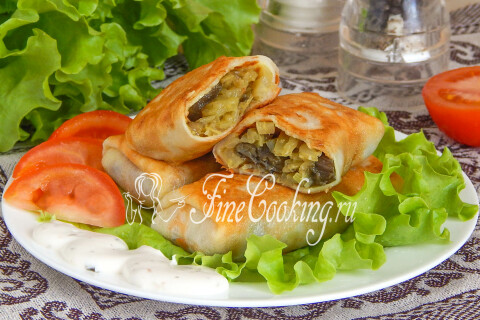 Блинчики с капустой и грибами, поданные со сметаной и свежей зеленью
