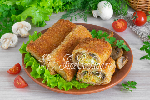 Готовые блинчики с капустой, грибами и яйцами на тарелке