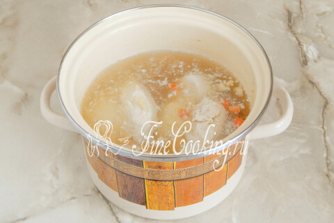Куриное филе, варящееся в кастрюле с кипящей водой и кореньями