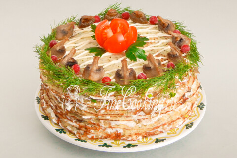 Блинный торт, украшенный дольками шампиньонов, укропом и клюквой