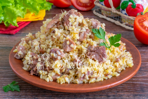 Готовый рассыпчатый булгур с тушёнкой на тарелке для подачи