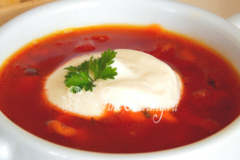 Тарелка детского борща с курицей, сметаной и свежей зеленью
