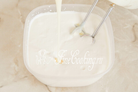 Сгущённое молоко, добавленное к взбитым сливкам в миске.