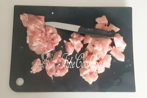 Нарезанные кусочками подмороженная куриная грудка и филе бедра.