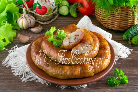 Колбаса из курицы на тарелке в окружении свежих овощей и зелени