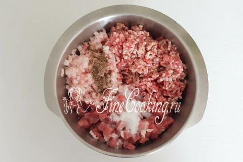 Молотый перец и соль, добавленные к мясному фаршу в миске.