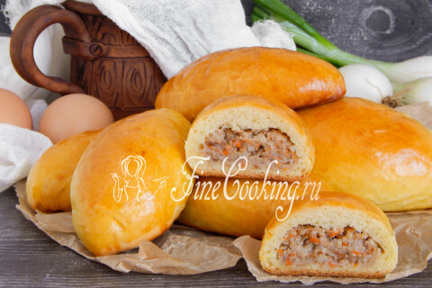 Сытные пирожки с мясом, сложенные горкой на плоской тарелке