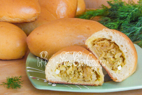 Пухлые пирожки с капустой и яйцами, сложенные горкой на тарелке