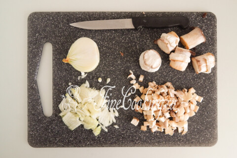 Лук и грибные ножки, нарезанные мелким кубиком, на разделочной доске