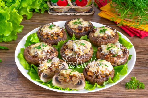 Шампиньоны, фаршированные сыром и луком, на тарелке в качестве закуски