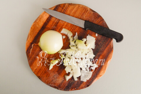 Крупная луковица, нарезанная мелким кубиком на разделочной доске