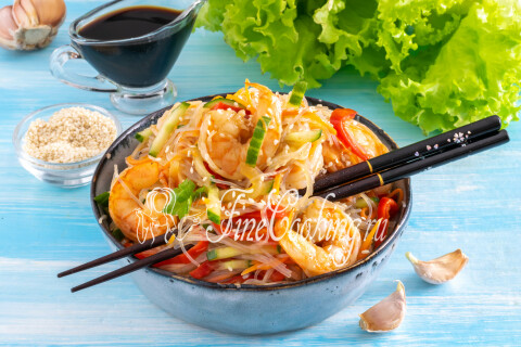 Фунчоза с креветками и овощами, посыпанная кунжутом и зелёным луком.