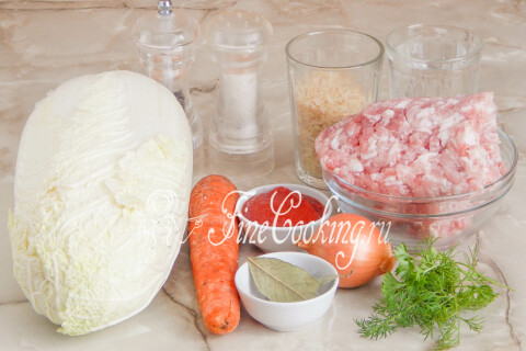 Продукты для голубцов с пекинской капустой: капуста, свиной фарш, рис, морковь, лук и зелень.