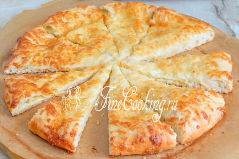 Горячая лепешка с сыром, у которой отрезан кусочек