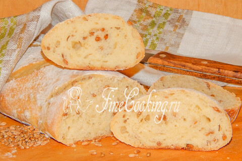 Ломоть хлеба с зёрнышками пшеницы и хрустящей корочкой на столе