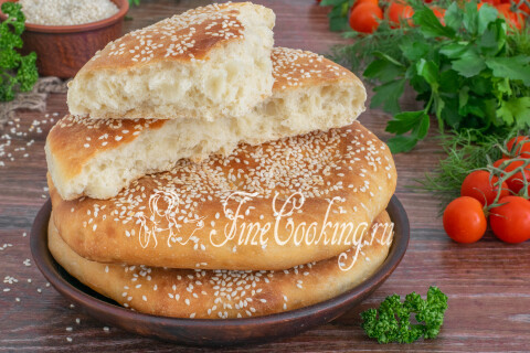 Готовые хлебные лепёшки с кунжутом на столе