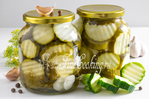Хрустящие маринованные кабачки на зиму, разложенные ломтиками в банке.