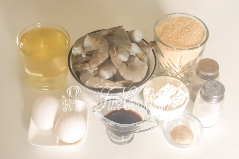 Продукты для жареных креветок в панировке: креветки, масло, сухари, яйца, мука, соевый соус, чеснок, соль и перец.