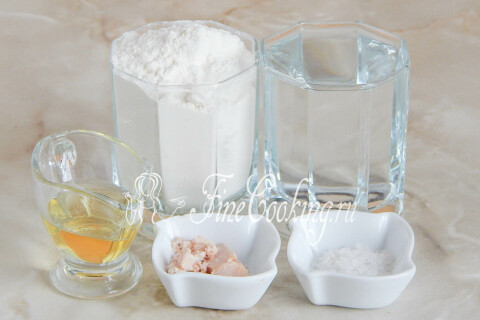 Продукты для дрожжевого теста для пиццы: мука, тёплая вода, соль, оливковое масло и дрожжи
