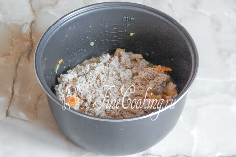 Ячневая крупа насыпана поверх мяса с овощами и разровнена
