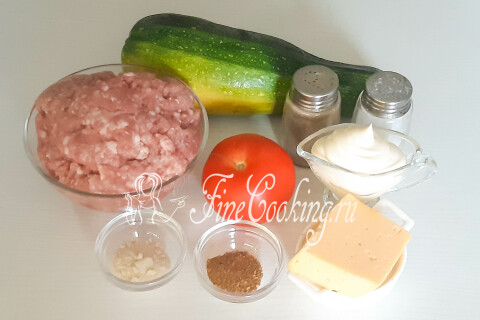 Продукты для кабачков с фаршем: кабачок, мясной фарш, помидоры, сыр, майонез, чеснок и приправы.