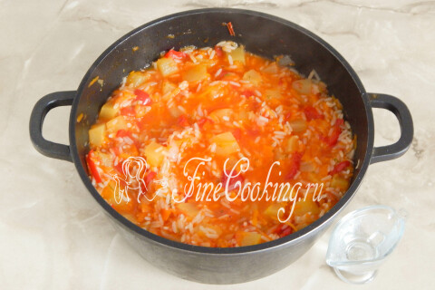Уксус влит в кастрюлю с овощами, рисом и специями
