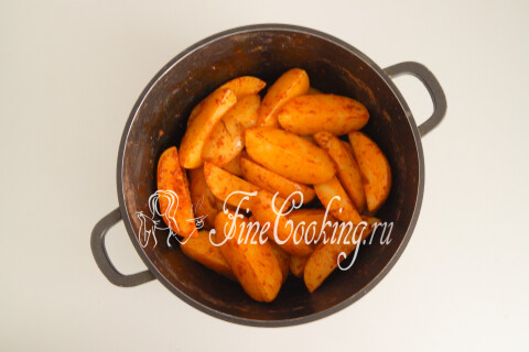 Картофельные дольки, покрытые смесью специй со всех сторон, в кастрюле