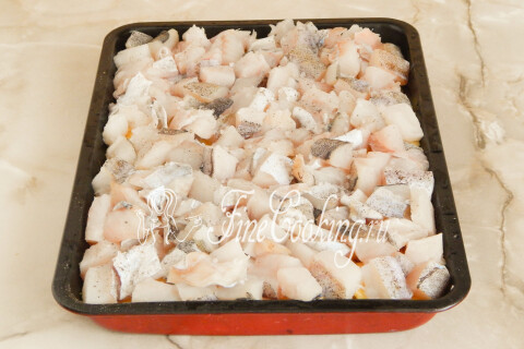 Кусочки рыбы, разложенные ровным слоем поверх картофеля