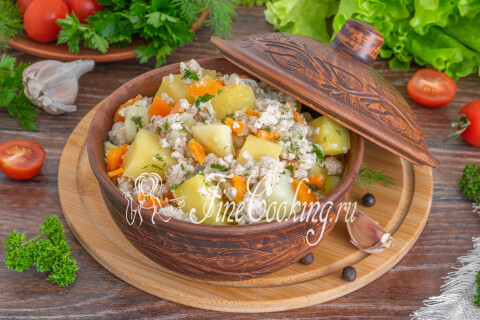 Картошка с фаршем на тарелке со свежими овощами и зеленью.