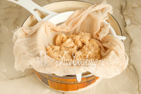Отжатое картофельное пюре в миске рядом с кастрюлей картофельного сока