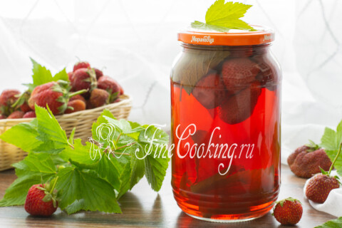 Готовый клубничный компот с листьями чёрной смородины в банке