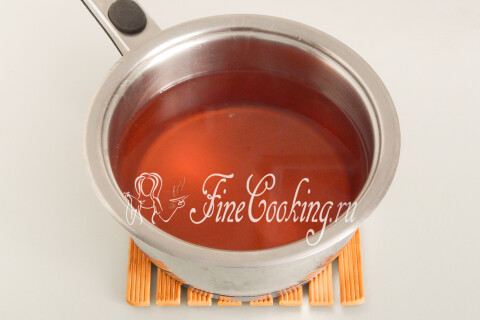 Клубничный настой с сахаром, закипающий в кастрюле на плите