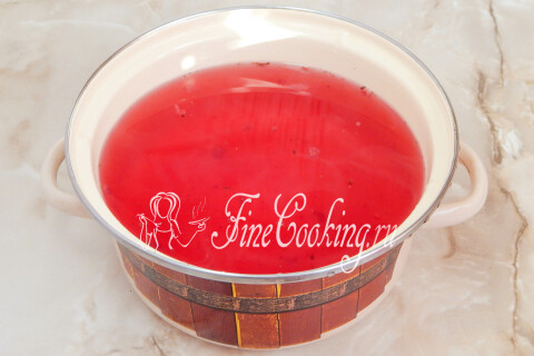 Ягодный сироп из смородины с сахаром, кипящий в кастрюле на плите