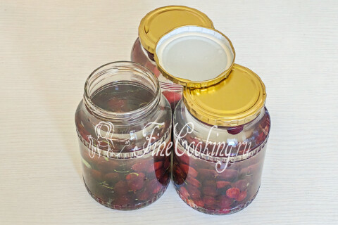 Банки с крыжовником, залитые кипятком и прикрытые крышками.