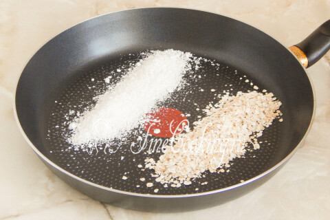 Овсяные хлопья и кокосовая стружка на сухой сковороде перед обжаркой.