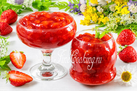 Густой клубничный конфитюр с кусочками ягод в стеклянной банке.