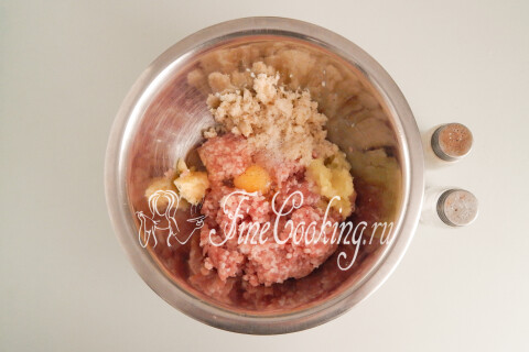Мясной фарш с луком, чесноком, батоном и яйцом в большой миске.