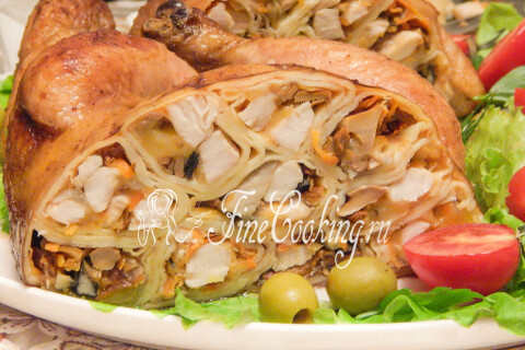 Разрезанная курица, фаршированная блинами, показывает слои начинки на срезе.