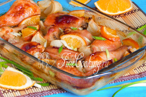 Запечённая курица с апельсинами на блюде, украшенная зелёным луком