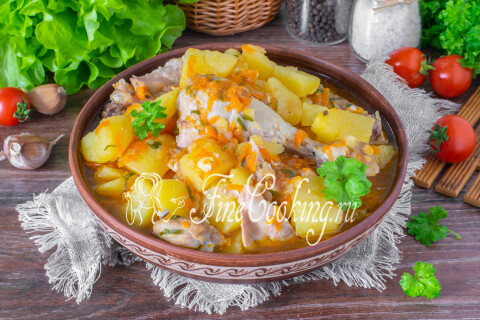 Курица с картошкой в густой овощной подливе, поданные к столу.