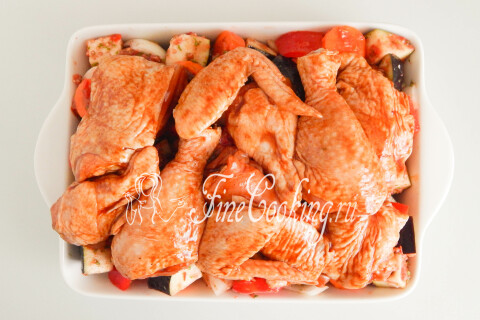 Маринованная курица, выложенная поверх слоя овощей в форме.