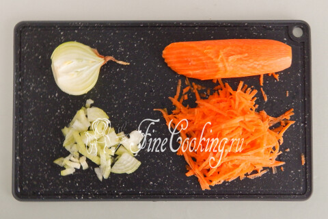 Лук, нарезанный кубиком, и морковь, натёртая на крупной тёрке, на разделочной доске