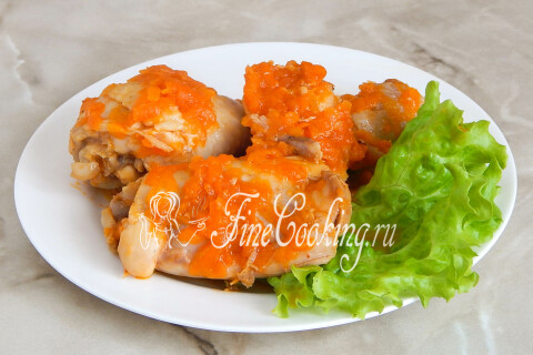 Тушёная курица с морковью на белой тарелке крупным планом
