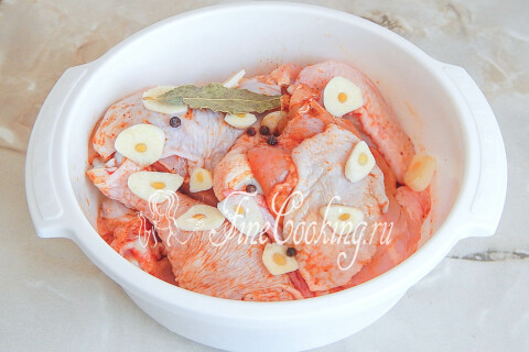 Лавровый лист и нарезанный тонкими ломтиками чеснок на курице