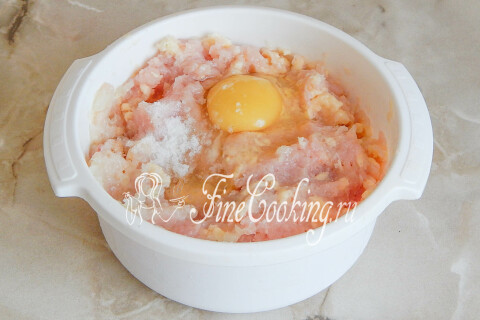 Куриное яйцо и соль, добавленные в куриный фарш с сыром и луком