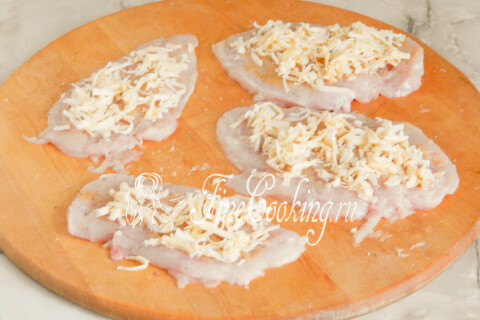 Тёртый сыр, разложенный поверх куриных отбивных