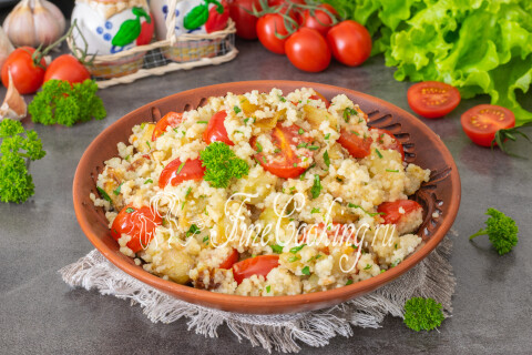 Тарелка с кускусом, баклажанами и помидорами, посыпанная петрушкой.